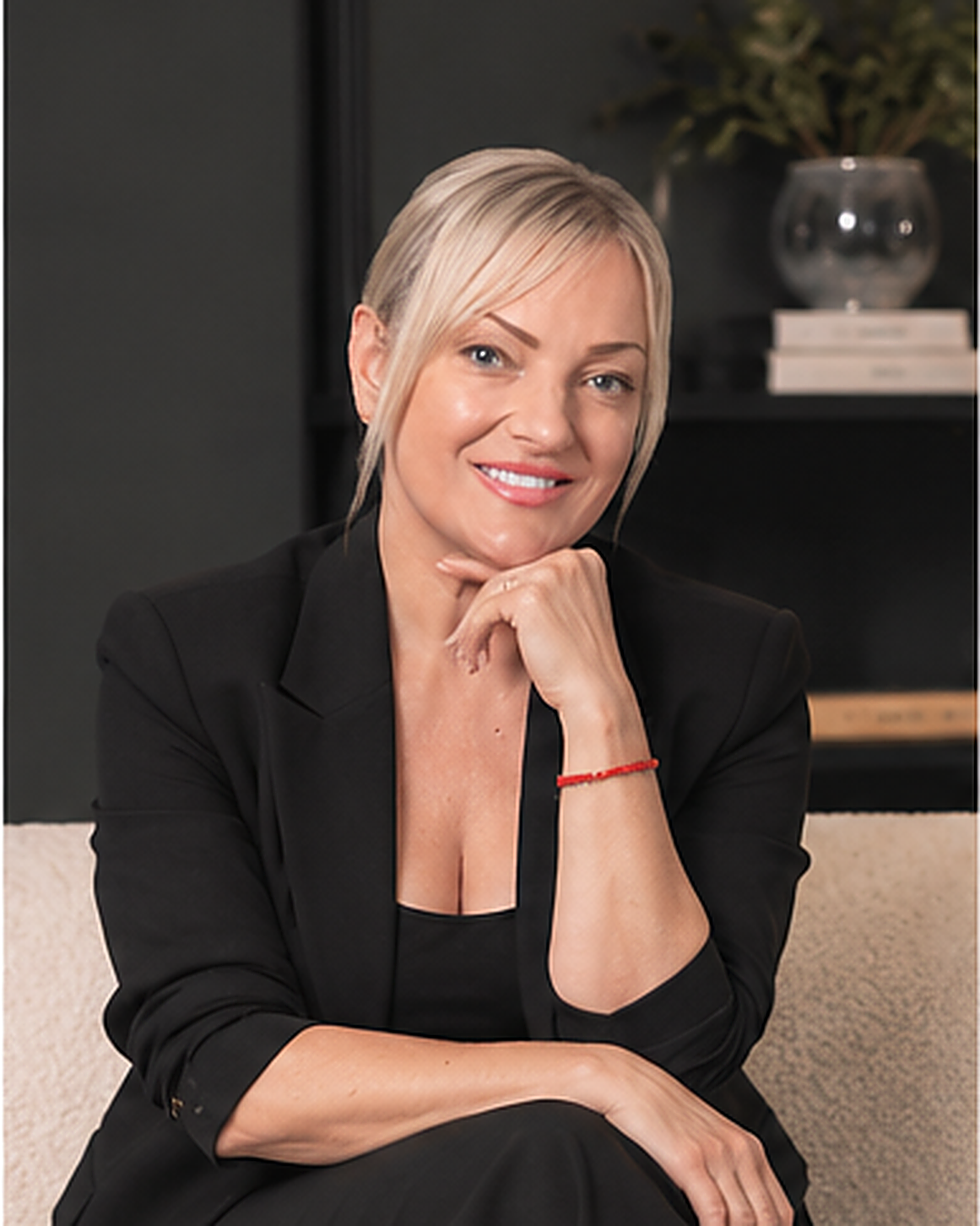 Dena Barabash, founder of DDI Brand Management, seated in a black suit